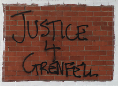 Justice for Grenfell graffiti on a brick wall.