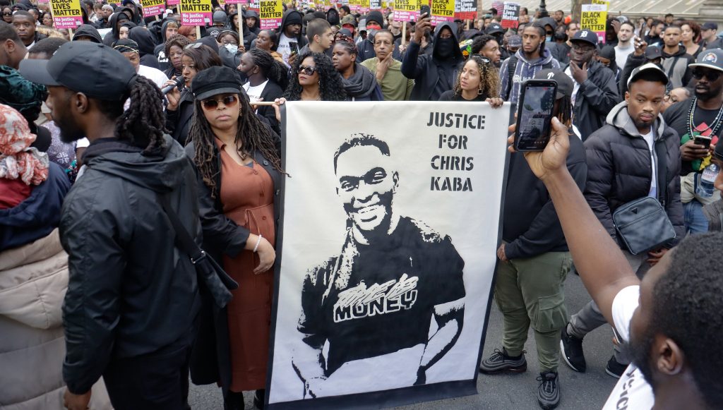 Protesters in central London holding up a banner saying Justice for Chris Kaba with an image of the 24-year-old in black and white.